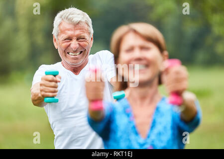 Senior Paar trainiert Kraft und Fitness mit Hanteln in rehab in der Natur Stockfoto
