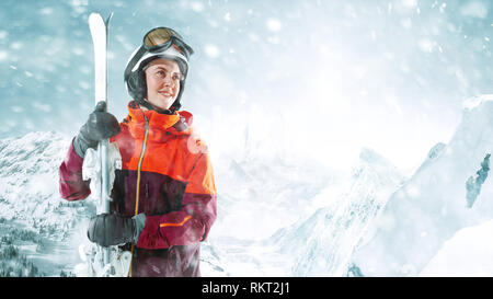 Skifahrerin stehend mit Himmel in einer Hand auf die schöne Berglandschaft im Hintergrund. Winter, Ski, Schnee, Urlaub, Sport, Freizeit, Lifestyle Konzept Stockfoto