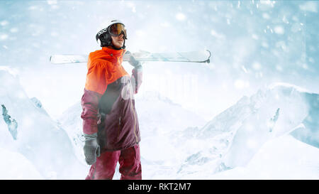 Skifahrerin stehend mit Himmel in einer Hand auf die schöne Berglandschaft im Hintergrund. Winter, Ski, Schnee, Urlaub, Sport, Freizeit, Lifestyle Konzept Stockfoto