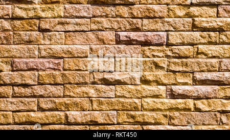 Muster der Braun moderne Stein Mauer aufgetaucht. Wand Hintergrund Foto. Grob strukturierte Ziegel in Bauernhaus Stil, ein authentisches Foto geschossen Stockfoto