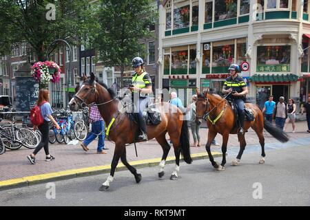 AMSTERDAM, NIEDERLANDE - 10 JULI 2017: Pferdesport Polizisten patrouillieren, Amsterdam. Polizei (politie) beschäftigt mehr als 63.000 Menschen in der Netherlan Stockfoto