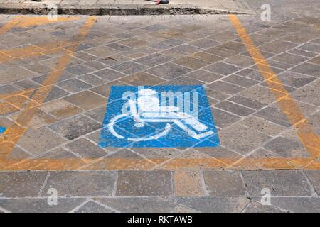 Behinderten Parkplatz - städtische Verkehrsinfrastruktur Fahrbahnmarkierungen in Italien. Stockfoto