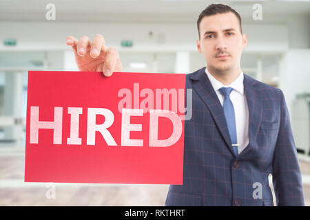 Mitarbeiter präsentieren rotes Papier mit angestellt Text als gefunden job Konzept Stockfoto