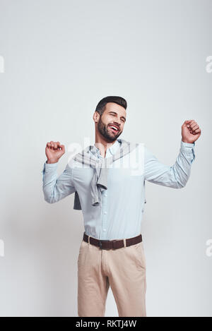 So müde. Süß und junger Mann fühlt sich schläfrig und müde nach der Arbeit beim Stehen in der Studio auf einem grauen Hintergrund. Close-up Portrait. Müdigkeit Stockfoto