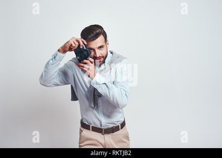 Netten Schuß. Attraktiven jungen Mann in Freizeitkleidung ist Fotografieren Sie beim Stehen in der Studio auf einem grauen Hintergrund. Close-up Portrait Stockfoto