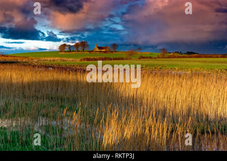 Ein Blick auf die St. Baglan's Kirche, Caernarfonshire, wie die Sonne. Stockfoto