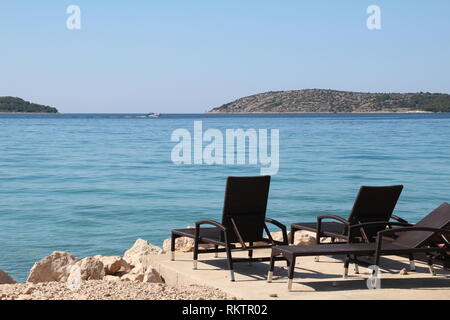 Adria/schönen kroatischen Strand mit Sonnenliegen. Stockfoto