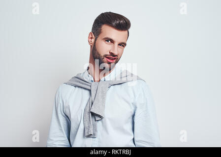 Wirklich? Hübscher junger Mann in Freizeitkleidung, Zweifel Gefühl beim Stehen gegen grauen Hintergrund. CLose-up. Zweifel Konzept Stockfoto