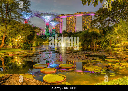 Beleuchtete Gärten an der Bucht bei Nacht mit dem Marina Bay Sands Hotel im Hintergrund, Singapur Stockfoto