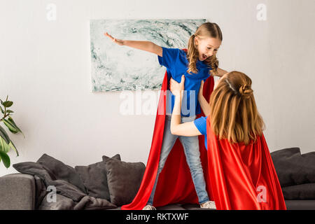 Mutter und Kind in rote Mäntel Spaß zu Hause in Stockfoto