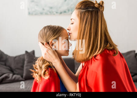 Schöne Mutter küssen süße Tochter zu Hause Stockfoto