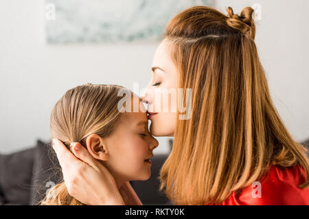 Nahaufnahme der Mutter küssen Tochter zu Hause Stockfoto