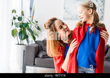 Kind und Mutter in rote Mäntel lächelnd und an jedem anderen Suchen Stockfoto