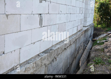 Haus Wand bereit für die Abdichtung von Fundament mit Isolierung. Isolierende äußere Grundmauern. Stockfoto