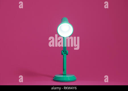 Retro grün Schreibtisch Lampe in der Mitte der Komposition eingeschaltet und geradeaus zeigen. Stockfoto