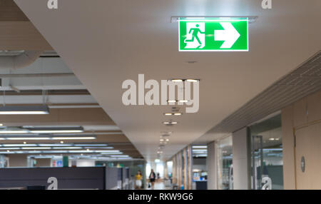 Grüne Notausgang Schild hängen an der Decke im Büro. Stockfoto