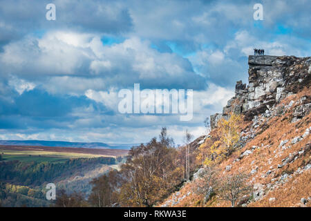 Eine Gruppe junger Leute schauen aus Curbar Kante in Derbyshire. Stockfoto