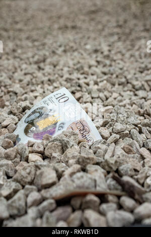 Zehn Pfund Sterling halb begraben. Stockfoto