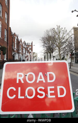 London, Großbritannien. 12 Feb, 2019. Kensington Church Street, London W8, doline. Eine Krähe prüft das dreckloch in Kensington Church Street, die unter einem Müllabfuhr Lkw am 07. Februar 2019 geöffnet ist immer noch zu Verzögerungen und Umleitungen zu Fahrzeugverkehr einschließlich der 27, 28 52, 70, 328, 452, N28, N31 Bus Routen wie Thames Water versuchen, sie zu füllen. Credit: Peter Hogan/Alamy leben Nachrichten Stockfoto