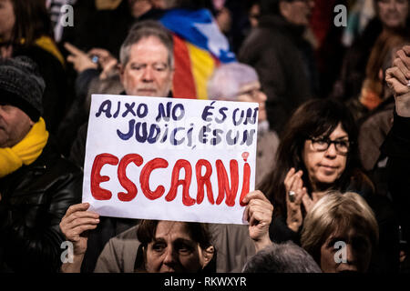 Eine Demonstrantin gesehen zeigt ein Plakat mit dem Text, dies ist nicht ein Versuch, es ist ein Hohn, während der Demonstration. Von den wichtigsten Entitäten und sovereignist Parteien einberufen, Tausende von Menschen haben an der Plaza Catalunya in einer öffentlichen Zeremonie versammelt, um die katalanische politische Gefangene Unterstützung am ersten Tag der Prüfung zu geben. Stockfoto