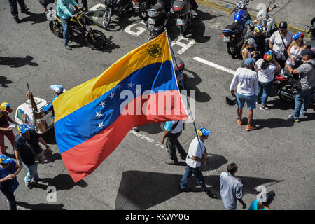 Caracas, Miranda, Venezuela. 12 Feb, 2019. Ein Mann gesehen, winkt eine riesige Flagge Venezuela während eines Protestes für eine änderung in der Regierung zu nennen. Gegner bei einem Protest organisiert von der PSUV (Vereinigte Sozialistische Partei Venezuelas) nach dem Aufruf von Interim Präsident Juan Guaido versammeln, um ihre Unterstützung zu, um ihn zu zeigen, während die Armee mehr humanitäre Helfer ins Land zu lassen. Credit: Roman Camacho/SOPA Images/ZUMA Draht/Alamy leben Nachrichten Stockfoto