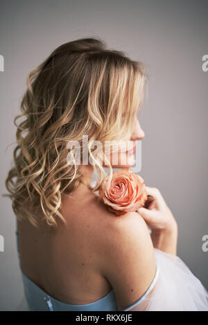 Schöne Braut in einem Bademantel mit einem Strauß Rosen. Stockfoto