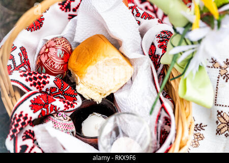 Orthodoxe Ostern Segen wicker Stroh Korb mit Brötchen und niemand auf Gras Boden außen an der Kirche mit Dekorationen und bestickte Handtuch Stockfoto