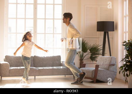 Leidenschaftlich gerne Vater und Kind Tochter tanzen zu Hause springen Stockfoto