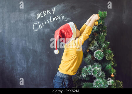 Der junge schrieb eine Aufschrift frohe Weihnachten. Weihnachtsbaum. Weihnachten und Neujahr Stockfoto