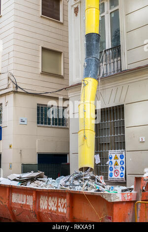 Malaga, Spanien - 23. März 2018. Geladen Müllcontainer in der Nähe eines Gebäudes in der Sanierung in Malaga, Spanien Stockfoto