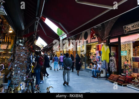 ISTANBUL, Türkei - 10 Juli 2017: Menschen Einkaufen in der Grand Bazar, handgefertigte Kissen, Taschen und Teppiche sind an der Wand zum Verkauf. Stockfoto