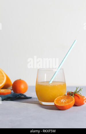 Ein Glas frisch gemachte Zitrusfrüchte auf einem hellen Hintergrund, vertikal Stockfoto
