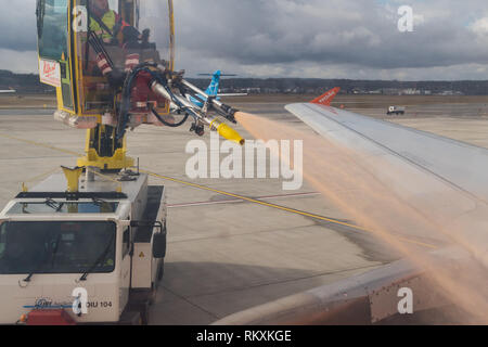 Arbeitnehmer Entfrostung die Flügel eines Easy Jet Flugzeug vor dem Start - Euroairport Stockfoto