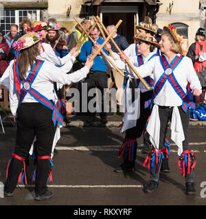 Englisch Morris Dancers in traditioneller Tracht, einschließlich Blumen und Glocken, die im Zentrum des Dorfes während der Joseph Bogen 100-Tag. Stockfoto