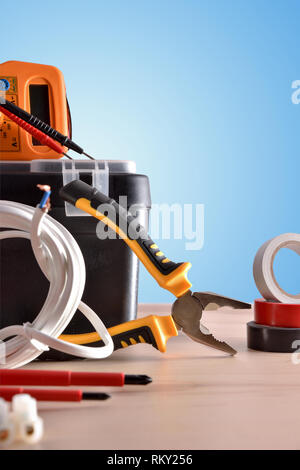 Vielzahl von Strom Tools auf einem Holztisch mit blauen Hintergrund. Vertikale Komposition. Vorderansicht. Stockfoto