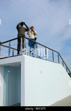 Figur aus Bronze Blick durch ein Fernglas und Tourist, Fotos auf dem Dach des Acebron Palace in Donana National Park, El Rocio, Spanien Stockfoto