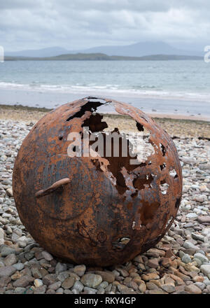 Eine alte und rostige Boje auf einem Kieselstrand in der Nähe der Küste an einem bewölkten Tag im Achiltibuie, Ross und Cromarty, Schottland Litze Stockfoto