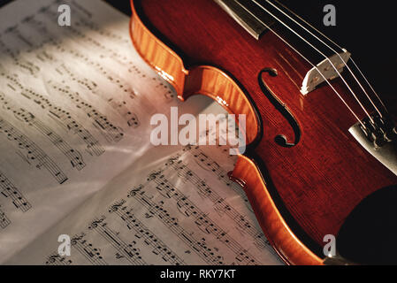 Wie zu lesen Violine Noten? Nahaufnahme von braunem Holz Geige liegen auf dem Blatt mit Noten. Musikinstrumente. Musik Equipment. Geigenunterricht Stockfoto
