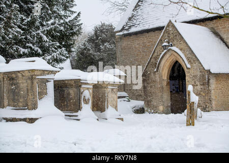 St Michael's Kirche und Friedhof im Winter Schnee. Winson, Cotswolds, Gloucestershire, England Stockfoto