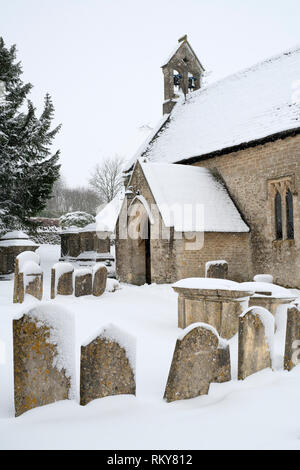 St Michael's Kirche und Friedhof im Winter Schnee. Winson, Cotswolds, Gloucestershire, England Stockfoto