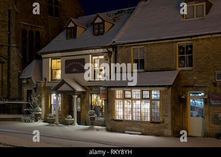 Marktplatz Geschäfte am frühen Morgen Schnee vor der Morgendämmerung. Verstauen auf der Wold, Cotswolds, Gloucestershire, England Stockfoto