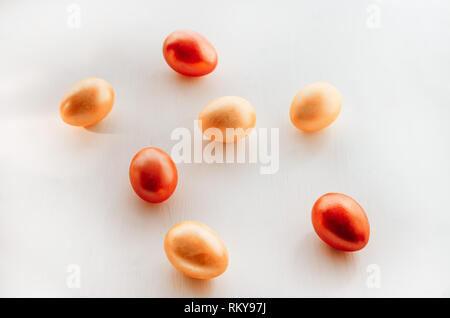 Bunte eier auf einem weißen Hintergrund. Kreative Ostern Konzept. Lebende Korallen - die Farbe des Jahres 2019. Stockfoto