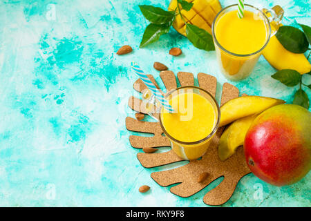 Superfoods und Gesundheit oder detox Diät Lebensmittel Konzept. Tropische Frucht Smoothies in Glasflaschen mit Mango und frische organische Smoothie Zutaten auf Stein Stockfoto