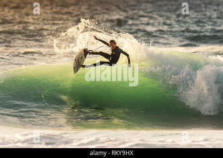 Ein junger Surfer auf einer Welle an Fistral in Newquay in Cornwall. Stockfoto