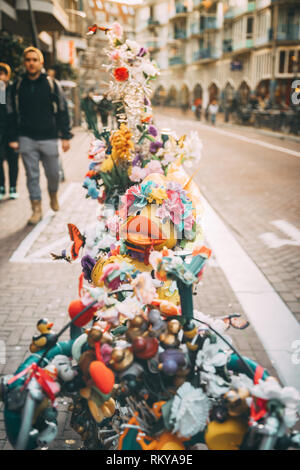 Eine bunt geschmückte Fahrrad auf einem Bürgersteig, Amsterdam. Stockfoto