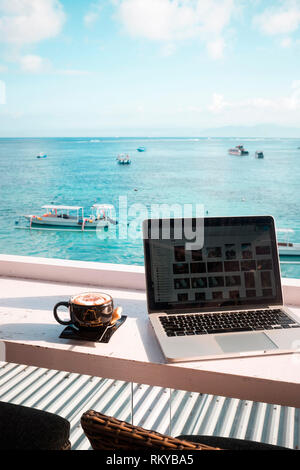 Laptop und Cappuccino mit Blick auf den Ozean. Stockfoto
