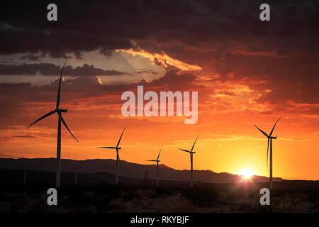 Wind Farm vor der Berge bei Sonnenuntergang. Stockfoto