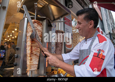 Koch schneiden chicken Kebab aus einer Street Food in Istanbul in der Türkei. Stockfoto