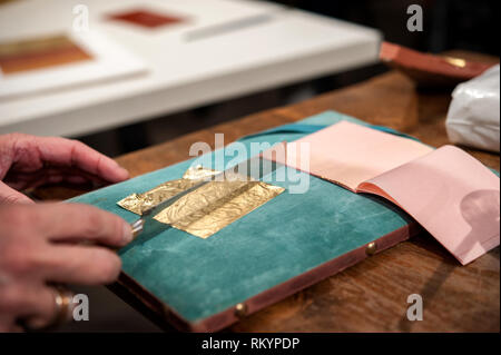 Handwerker schneidet ein extrem dünnes Blattgold für die vergoldung Technik. Stockfoto