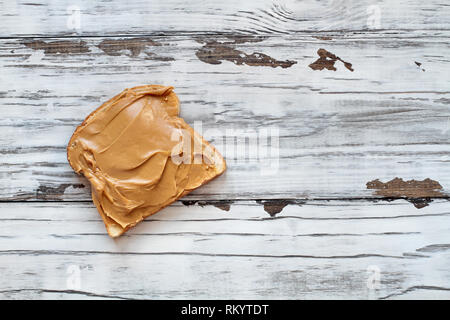 Öffnen konfrontiert Peanut butter Sandwich auf Hafer Brot, über eine rustikale weiße Holztisch/Hintergrund. Ansicht von oben. Stockfoto